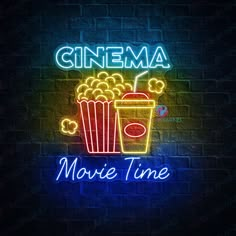 a neon sign that says cinema movie time with a drink and popcorn bucket on it