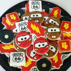 decorated cookies are arranged in the shape of cars and lightning boltes on a plate