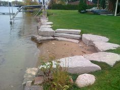 some rocks and grass by the water