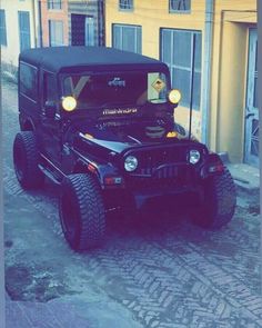 a jeep is parked in front of a yellow building