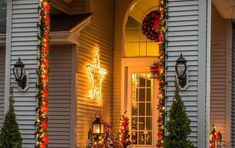 christmas decorations on the front porch of a house with lights and wreaths around it