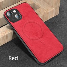 a red iphone case sitting on top of a wooden table next to a phone holder