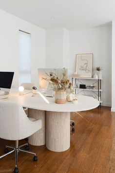 a white table with two chairs and a laptop on it