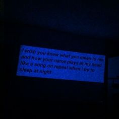 a message is projected in the dark on a wall with blue light from behind it