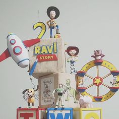 a very tall tower with some toy figurines on it's sides and an airplane in the background