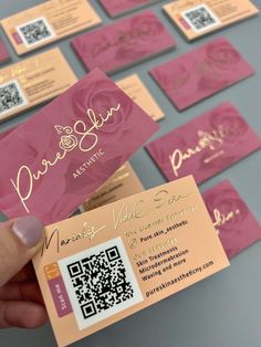 a person holding up a pink business card