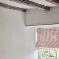 a window with a red and white striped roman blind on it's valance