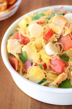 a white bowl filled with food on top of a wooden table