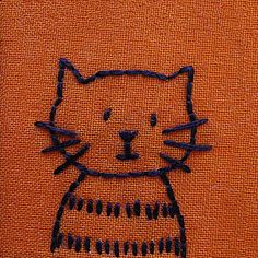 an orange piece of cloth with a cat drawn on it