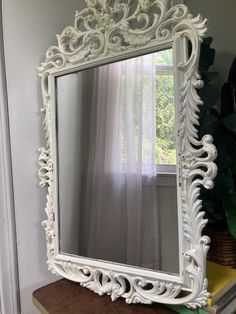 a white mirror sitting on top of a wooden table