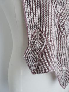 a close up of a knitted shawl on a mannequin