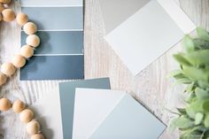 several different shades of gray and white are on the table next to some green plants