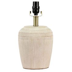 a white ceramic urn with a black lamp on it's side and a gold base