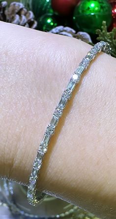 Glamour meets elegance with our 1.74ct tw diamond baguette and round alternating bracelet. Alternating diamonds in both baguette and round cuts create a stunning and unique design. Bring luxury to any outfit and make a statement with this beautiful piece. Metal: 18K White GoldDiamond Shape , Weight: (82) Round Cuts 1.89ctw, (54) Baguette Cuts 2.08ctwDiamond Total Weight: 3.97ct twBangle/Wrist Width: 53mm x 45mmBangle Width: 7mm Diamond Baguette, Baguette Cut, Baguette Diamond, Round Cut, Diamond Bracelet, Unique Design, Unique Designs, Diamonds, White Gold