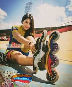 a woman sitting on top of a skateboard next to a colorful ball bearing wheels