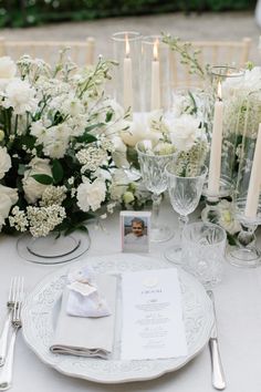 the table is set with white flowers and candles