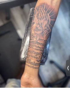 a person with a tattoo on their arm holding up a hand and praying to god