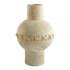 a white vase that has some brown crosses on it and is sitting in front of a white background