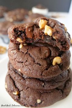 A stack of dark chocolate cookies on a white plate with a bite taken out of the top cookie. Double Dark Chocolate Cookies, Dark Chocolate Cookies