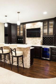 a kitchen with black cabinets and white counter tops