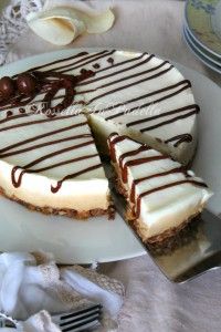 a white plate topped with a cheesecake covered in chocolate