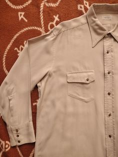 FOR SALE - 1940s Towncraft western shirt. In a size XL. Beige with hint of pink cotton, slanted pocket flaps, button closure, 40s style point collar. Measurements: Shoulders: 19" Sleeves: 21.5 Chest: 25" Length: 33" In mint condition. No flaws seen. Vintage Cotton Mens Dress Shirt, Vintage Shirt With Pockets At Affordable Price, Retro Solid Color Shirt With Button Closure, Retro Solid Shirt With Button Closure, Vintage Collared Shirt For Rodeo, Vintage Collared Tops For Rodeo, Vintage Single Breasted Button-up Tops, Vintage Button-up Shirt For Rodeo, Vintage Single-breasted Button-up Tops