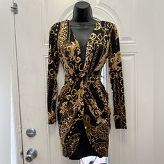 a black and gold robe on display in front of a white door