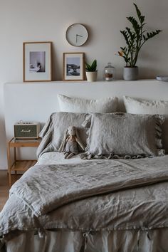 there is a bed with many pillows and blankets on top of it in the room