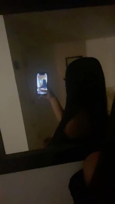 a woman is taking a selfie with her cell phone in the mirror while standing up