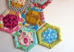 a bunch of hexagons are hanging on the wall with text that reads quilt as you go hexagons