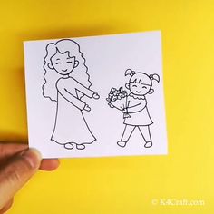 a hand holding a piece of paper with a drawing of a woman and child on it