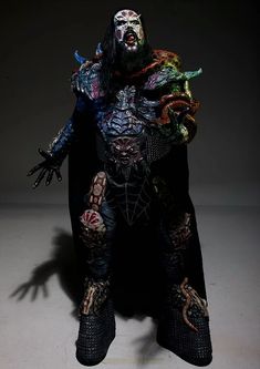 a man dressed up as a demon standing in the dark