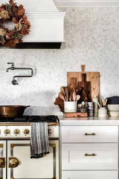 an image of a kitchen with white cabinets and gold accents on the counter top, along with pots and pans