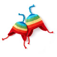 two crocheted hats are laying on top of each other, one is red and the other is blue