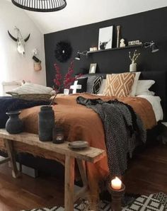 a bed room with a neatly made bed next to a night stand and some candles