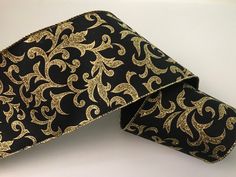 a black and gold patterned tie laying on top of a white table