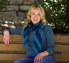 a woman sitting on top of a wooden bench