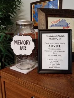 there is a framed sign on the table next to a jar with an advertiser's name in it