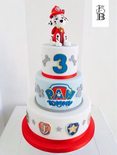 a three tiered cake with a dog on top