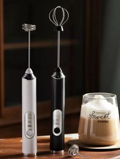 two electric toothbrushes sitting next to each other on a table with a cup of coffee