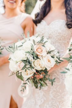 two bridesmaids holding bouquets of white and pink flowers