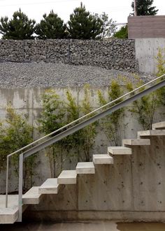 a man riding a skateboard down the side of a set of stairs next to a cement wall