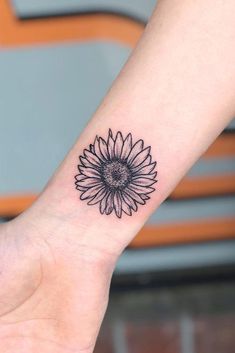 a small sunflower tattoo on the wrist