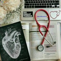 an open book with a stethoscope on top of it next to a laptop