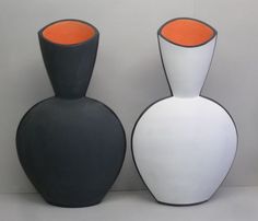 two black and white vases sitting next to each other