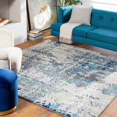 a living room with blue couches and white rugs on the hardwood flooring