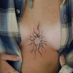 a woman's chest with a sun tattoo on it