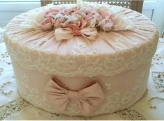 there is a large pink cake with bows on it's top and lace around the edges