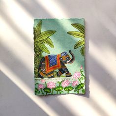 an elephant on a green background with pink flowers and palm trees in the sun light