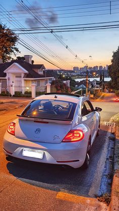 a car parked on the side of the road at dusk with power lines in the background